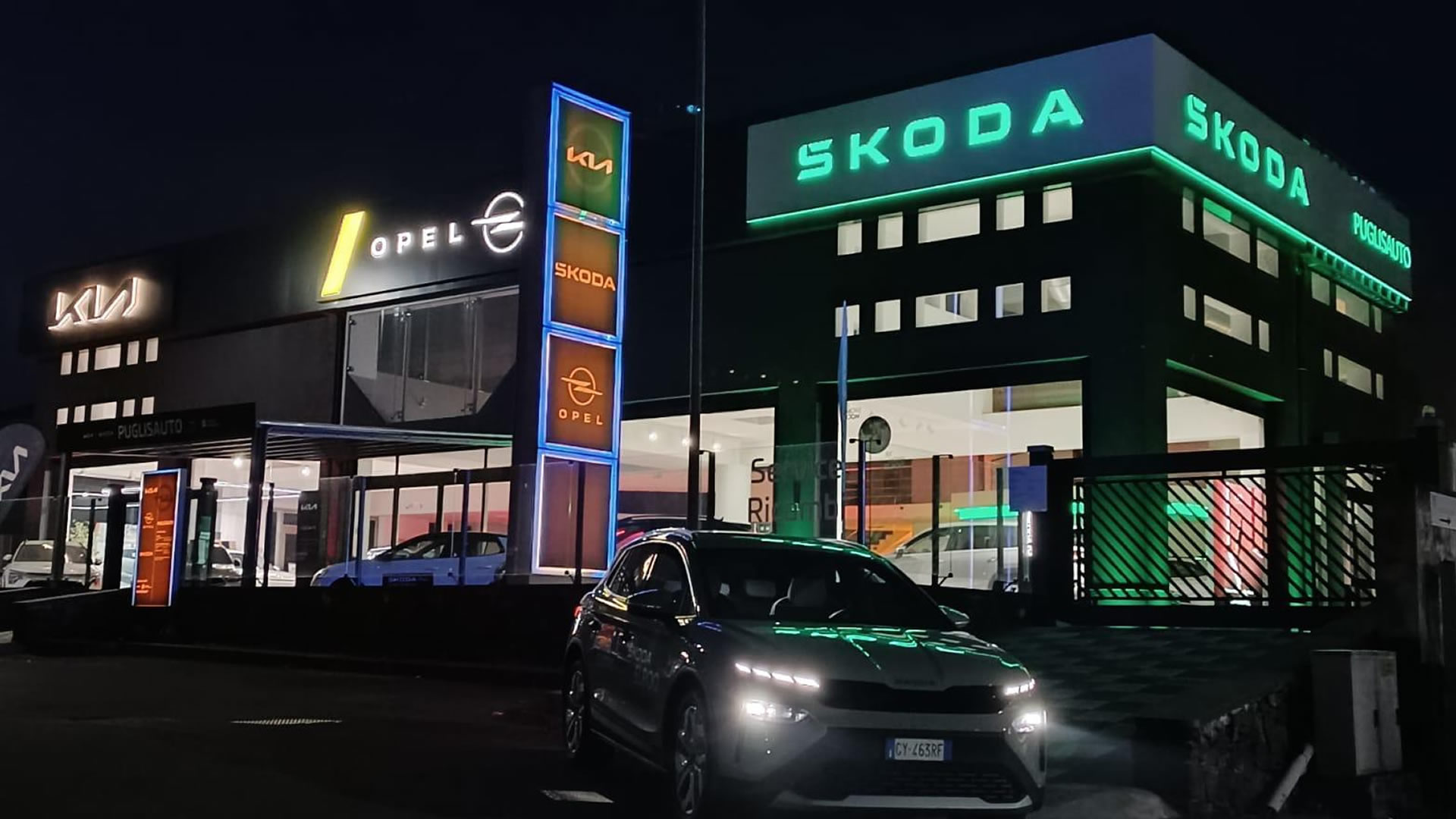Insegne luminose Kia, Opel e Škoda della concessionaria Puglisauto di notte